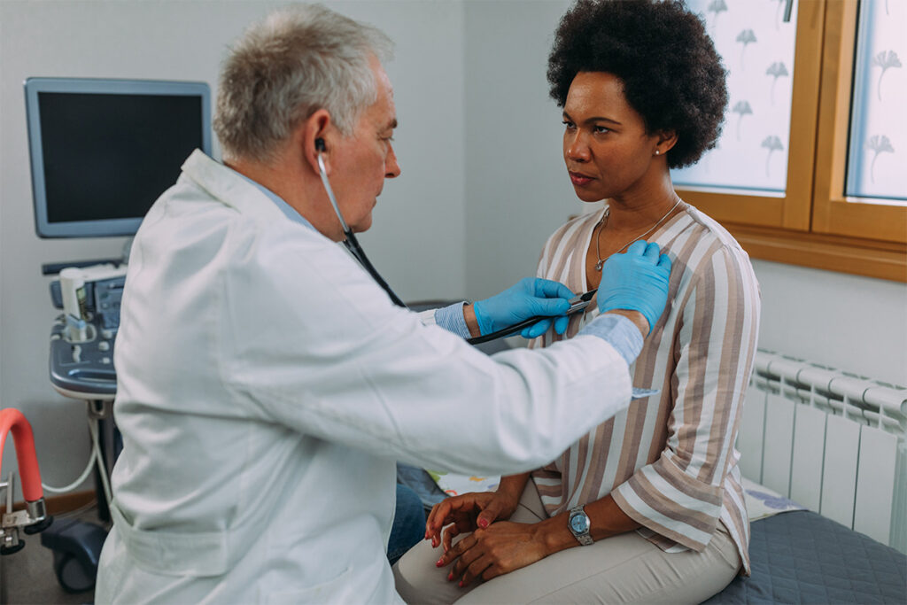 Provider listening to a patient’s heartbeat during a flu and cold checkup at Affinity Urgent Care.